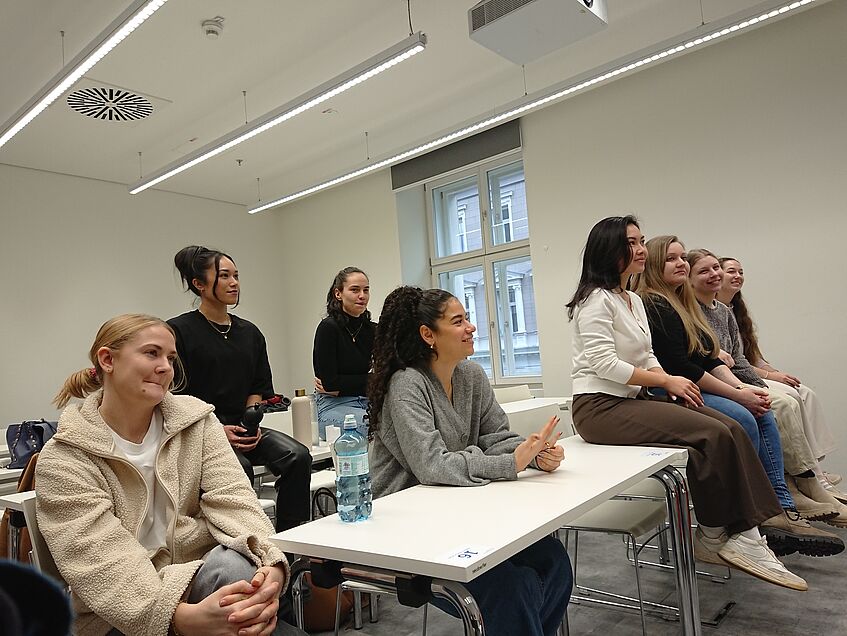 Studierende der Forschungswerkstatt im Lehrsaal zuhörend